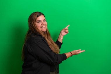 Elleriyle poz veren genç bir kadın için yeşil arka plan herhangi bir renge dönüşebilir.