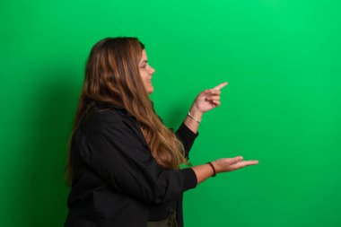 Elleriyle poz veren genç bir kadın için yeşil arka plan herhangi bir renge dönüşebilir.