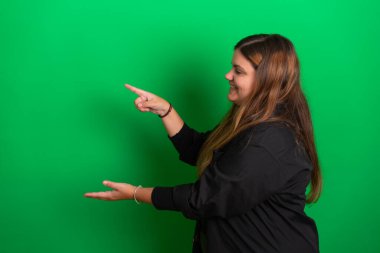 Elleriyle poz veren genç bir kadın için yeşil arka plan herhangi bir renge dönüşebilir.