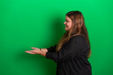 Elleriyle poz veren genç bir kadın için yeşil arka plan herhangi bir renge dönüşebilir.