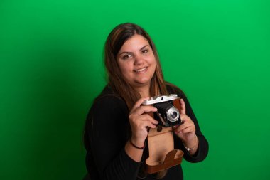 Elinde antika fotoğraf makinesi olan genç bir kadın, yeşil arka plan herhangi bir renge kolayca dönüştürülebilir.