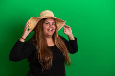Şapkalı genç bir kadın, yeşil arka planda herhangi bir renge dönüşebilir.