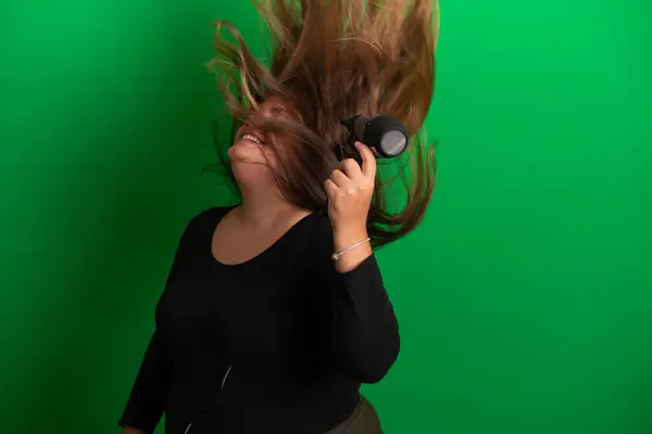 拥有吹风机的年轻女人 绿色背景很容易转变为任何一种颜色 — 图库照片