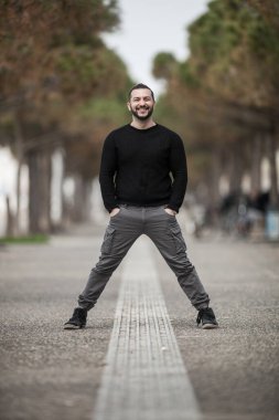 Doğal görünüşlü, açık havada poz veren, günlük kıyafetler giyen, montaj yapmayan biri.