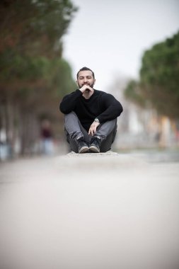 Doğal görünüşlü, açık havada poz veren, günlük kıyafetler giyen, montaj yapmayan biri.