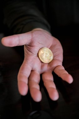 El ele tutuşmak ve altın bir Bitcoin göstermek, kripto para birimi için bir kavram 