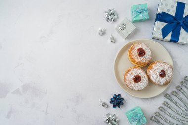 Geleneksel donutlar, menoralar ve hediye kutusuyla Yahudi bayramı Hanuka arkaplanı. Üst manzara, düz uzanma