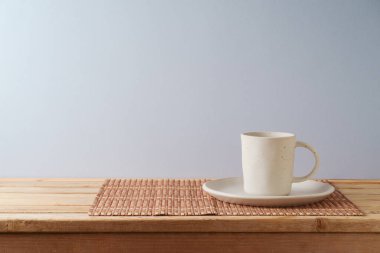 Kahve fincanı, arka plandaki ahşap masada. Mutfak tasarım ve ürün gösterimi için hazırlandı.