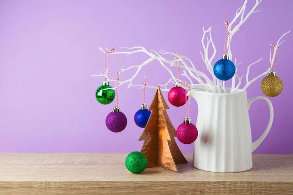 紫色の背景に木製の棚の上に創造的な装飾とクリスマス休暇の概念 白い枝にぶら下がってクリスマスの泡 — ストック写真