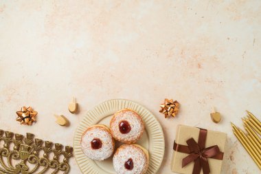 Geleneksel donutlar, menoralar ve taş arka planda hediye kutusuyla Yahudi bayramı Hanukkah konsepti. Üst manzara, düz uzanma
