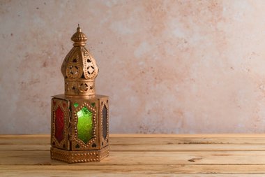 Taş duvar zemininin üzerindeki ahşap masada fener yakılmış. Ramazan kareem bayramı konsepti