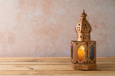 Taş duvar zemininin üzerindeki ahşap masada fener yakılmış. Ramazan kareem bayramı konsepti