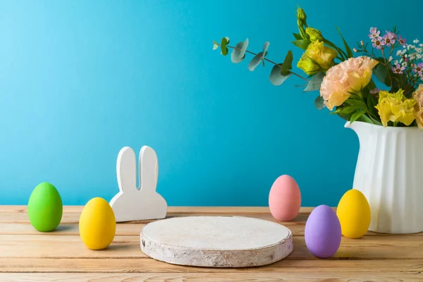 复活节假期的概念与木制原木 复活节蛋和花卉在木制桌子上蓝色背景 用于设计和产品展示的弹簧模型 — 图库照片