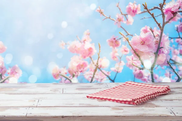 在樱花背景上铺有桌布的空木桌 春季和复活节模拟设计和产品展示 — 图库照片