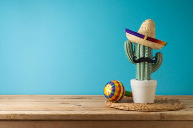 Meksika partisi konsepti kaktüs, marakas ve ahşap şapkalı mavi arka plan. Cinco de Mayo bayram kutlaması