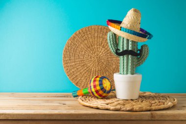 Meksika partisi konsepti kaktüs, marakas ve ahşap şapkalı mavi arka plan. Cinco de Mayo bayram kutlaması
