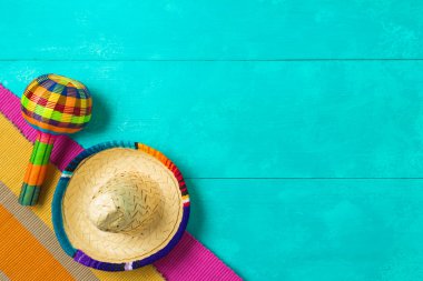 Meksika parti süslemeleri. Mavi ahşap arka planda şapkası ve marakası var. Cinco de Mayo bayram kutlaması. Yukarıdan üst görünüm