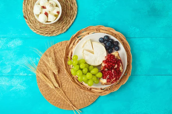 ユダヤ人の休日木製の青いテーブルの背景にチーズ 果物や小麦の耳でShavuotお祝いのテーブルの設定 上からの眺め — ストック写真