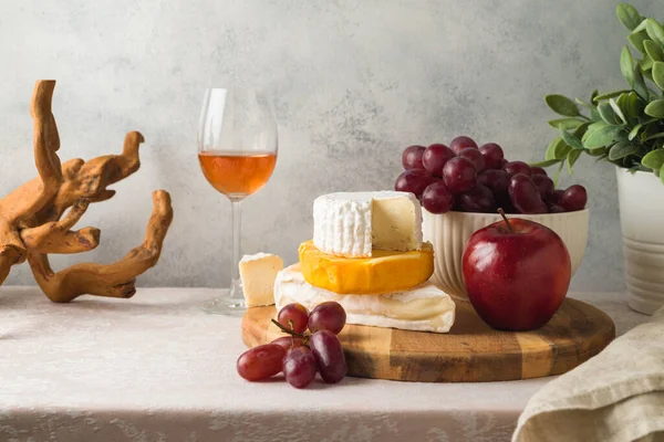 Masanın Üzerinde Peynir Üzüm Fındık Şarap Kadehi Olan Natürmort — Stok fotoğraf