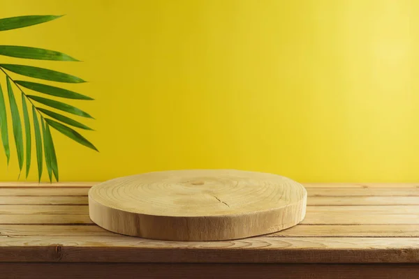 Leere Holzstämme Mit Palmenblättern Auf Einem Holztisch Vor Gelbem Hintergrund — Stockfoto