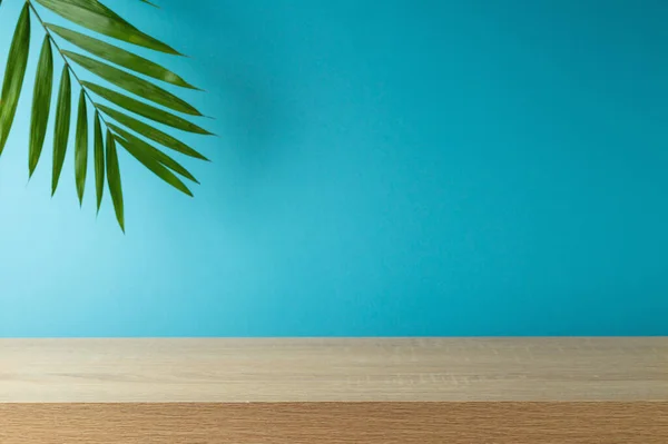 青い背景にヤシの木の葉と空の木製のテーブル デザインと製品表示のための夏のモックアップ — ストック写真