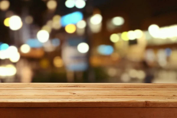 抽象的なぼやけたボケの夜のライトの背景に空の木製のテーブル デザインと製品表示のためのモックアップ — ストック写真