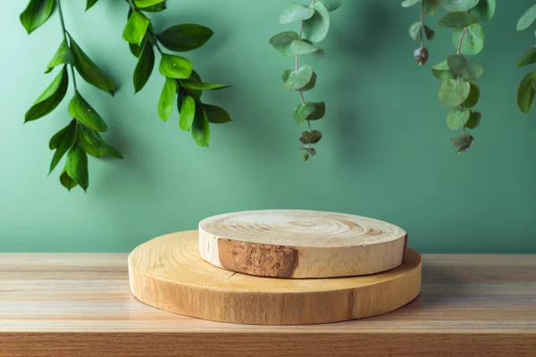 Leere Holzpodeste Auf Einem Tisch Mit Eukalyptusblättern Vor Grünem Hintergrund — Stockfoto