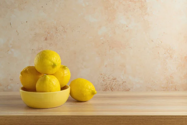 用黄色碗装的柠檬放在木制的现代桌子上 厨房模拟设计和产品展示 — 图库照片