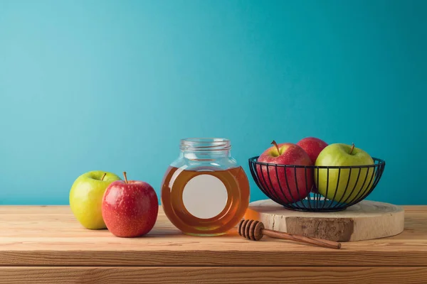蜂蜜罐和苹果放在蓝色背景的木制桌子上 犹太假日Rosh Hashanah概念 — 图库照片