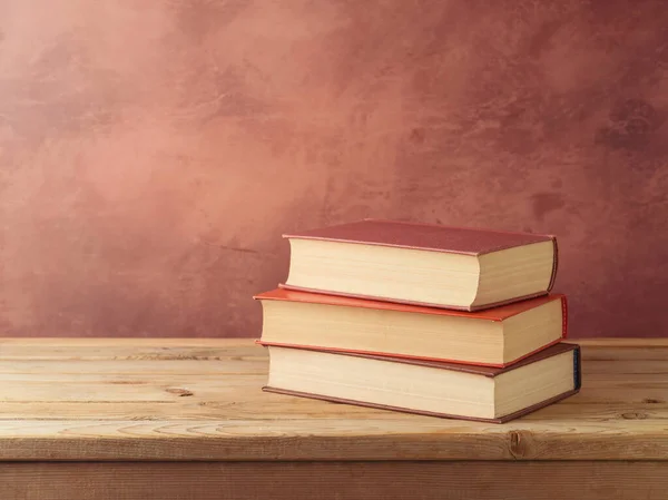 壁の背景に木製のテーブルの上の本のスタック 学校のコンセプトに戻る — ストック写真