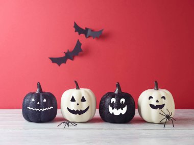 Cadılar Bayramı konsepti Jack o fener komik balkabağı süslemesi ahşap beyaz masa üzerinde pembe arka plan