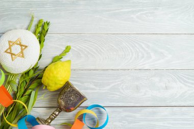 Jewish holiday Sukkot concept with traditional symbols on wooden background. Top view, flat lay