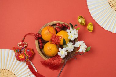 Çin Yeni Yıl kutlamaları ve kırmızı arka planda geleneksel bahar festivali dekorasyonları. Üst manzara, düz yatış. Çince metin: servet, şans ve zenginlik