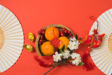 Çin Yeni Yıl kutlamaları ve kırmızı arka planda geleneksel bahar festivali dekorasyonları. Üst manzara, düz yatış. Çince metin: 