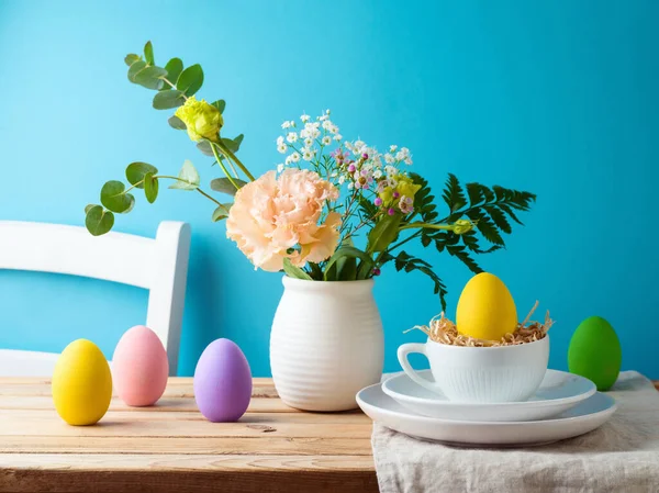 Osterfest Eierdekoration Und Blumenstrauß Auf Holztisch Über Blauem Hintergrund Stockbild