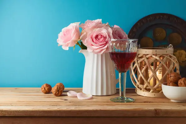 ユダヤ人の休日青い背景の上に木製のテーブルの上にワイングラス マツアと花と過越の概念 ストックフォト