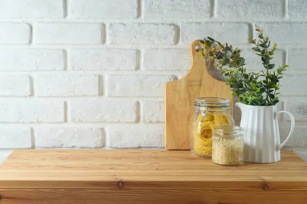 Leerer Holztisch Mit Pflanze Gefäßen Und Schneidebrett Vor Weißem Backsteinhintergrund Stockfoto