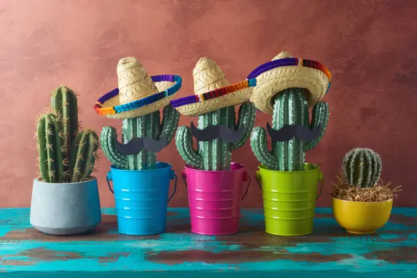 壁の背景に木製の青いテーブルの上にカクタスとソンブレロの帽子を用いたメキシコのパーティーコンセプト シンコ メイヨー ホリデー お祝い ロイヤリティフリーのストック画像
