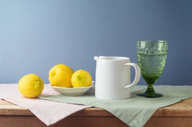 Mutfak masasında limon ve beyaz sürahi ile yaz kompozisyonu