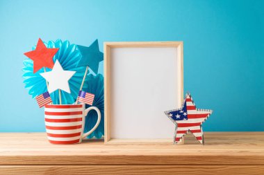 Mutlu Bağımsızlık Günü, 4 Temmuz kutlamaları çerçeveli konsept; dekorasyonlar ve ahşap masa üzerindeki Amerikan bayrağı mavi arka plan