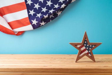Bağımsızlık Günü 'nüz kutlu olsun, 4 Temmuz kutlamaları konsepti yıldız süslemesi ve ahşap masada mavi arka planda Amerikan bayrağı.