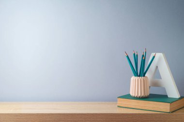 Kalemleri, kitabı ve ürün gösterimi için boş alanı olan masaüstü. Okul geçmişine dönelim.