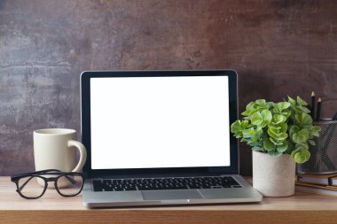 Dizüstü bilgisayar, modern ofis masasına dizüstü bilgisayar, kahve fincanı ve bitki ekiyor. İş ve ofis kavramı