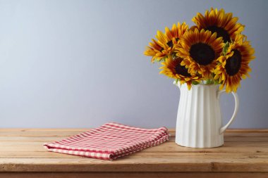 Boş ahşap masa, ayçiçekleri ve masa örtüsü. Şükran Günü arkaplanı tasarım ve ürün gösterimi için hazırlanır.