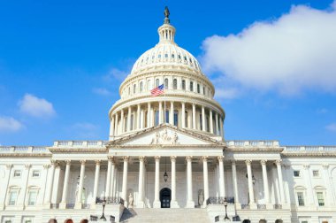 Mavi gökyüzü arkaplanı üzerinde Amerikan bayrağı bulunan Birleşik Devletler Kongre Binası, Washington DC