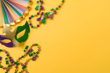 Karnaval ya da Mardi Gras parti konsepti. Karnaval maskeleri, boncuklar ve sarı arka plan.