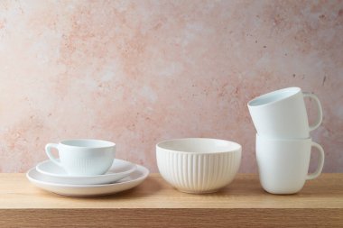 Mutfak beyaz bulaşık takımı, kahve fincanları ve tabaklar ahşap rafta. Mutfak içi arka plan