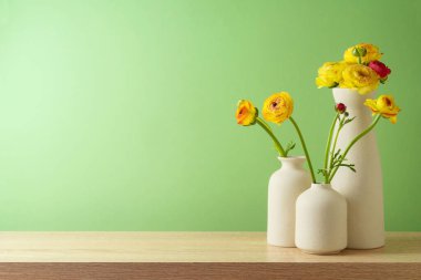 Çağdaş vazoda çiçekli bahar ve Paskalya konsepti yeşil duvar arka planında. Ürün gösterimi için iç tasarım modeli