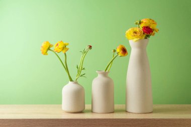 Çağdaş vazoda çiçekli bahar ve Paskalya kavramı yeşil duvar arka planında