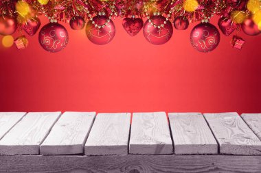 Kırmızı çelenk ve süslemeleri olan boş bir Noel masası. Kış tatili tasarım ve ürün gösterimi için hazırlanıyor.